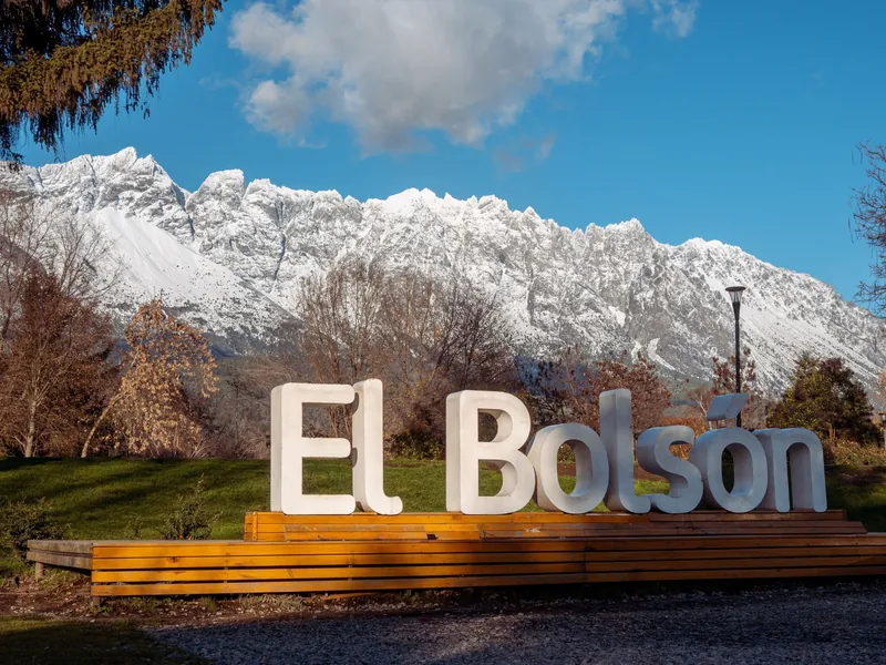 Cartel de El Bolsón frente a la cordillera nevada